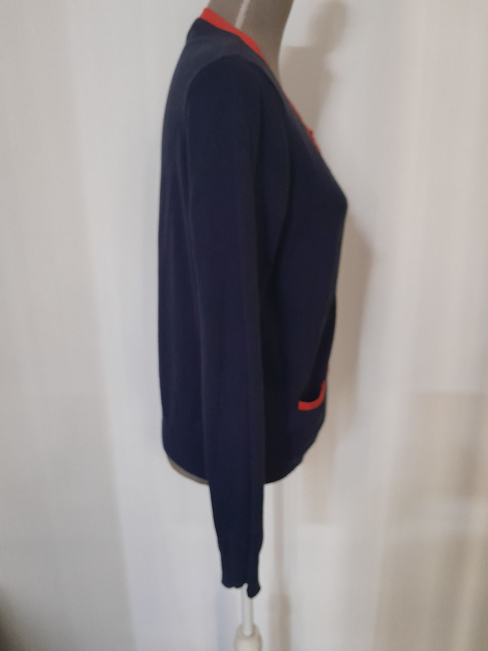 Miniature : Femme vêtue d'un pull bleu marine. Blouson avec des poches orange visibles.