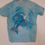 Miniature : T-shirt bleu avec un dauphin et des vagues, Seconde Main.