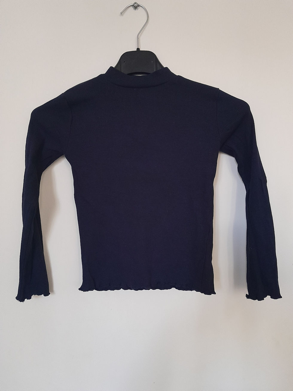 Un haut bleu marine avec un col montant et des manches longues. Seconde Main