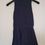 Miniature : Robe bleu marine, suspendue à un cintre noir sur fond blanc, Seconde Main.