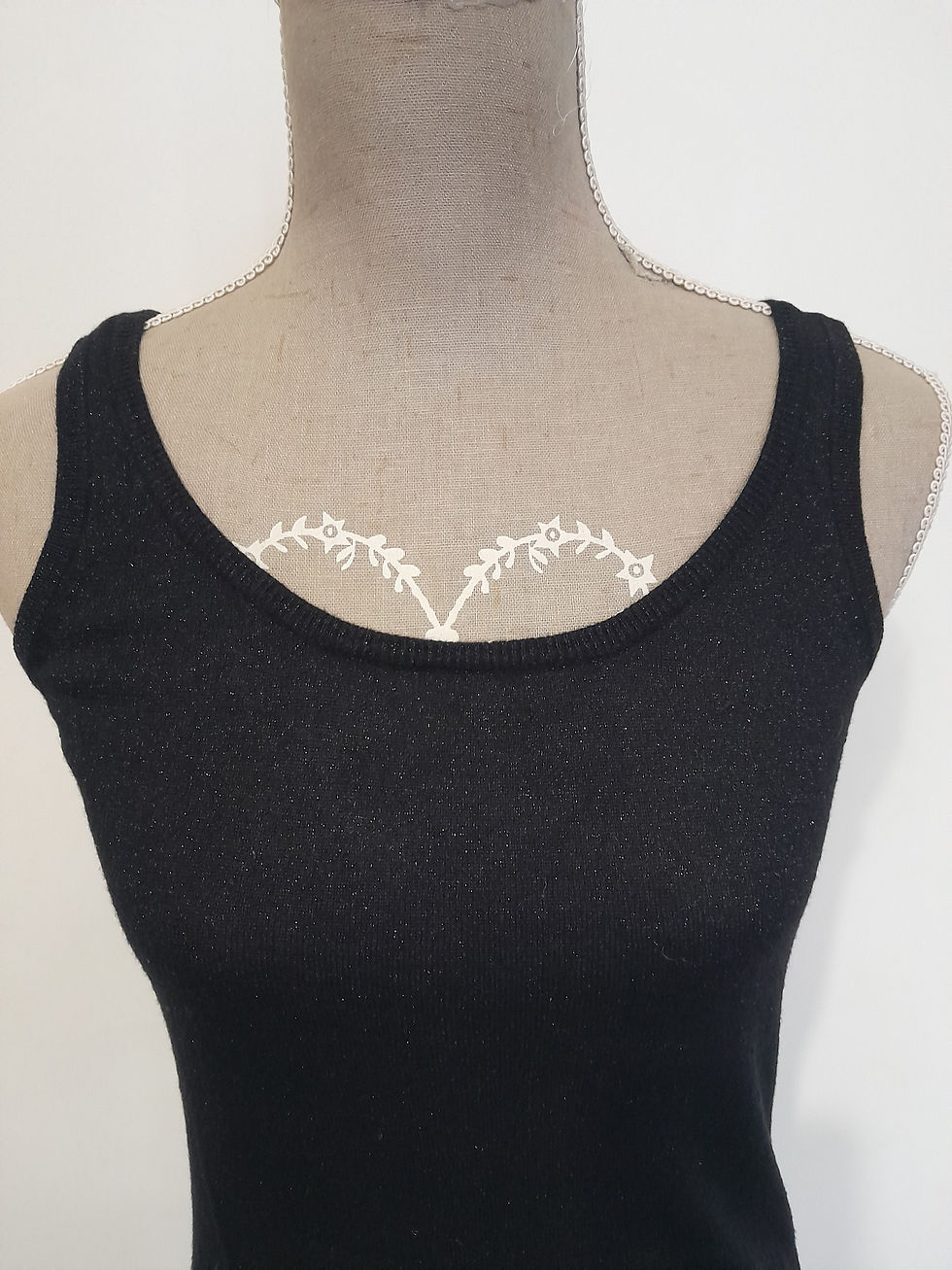 Miniature : Un haut noir avec un détail de dentelle blanche sur un mannequin.