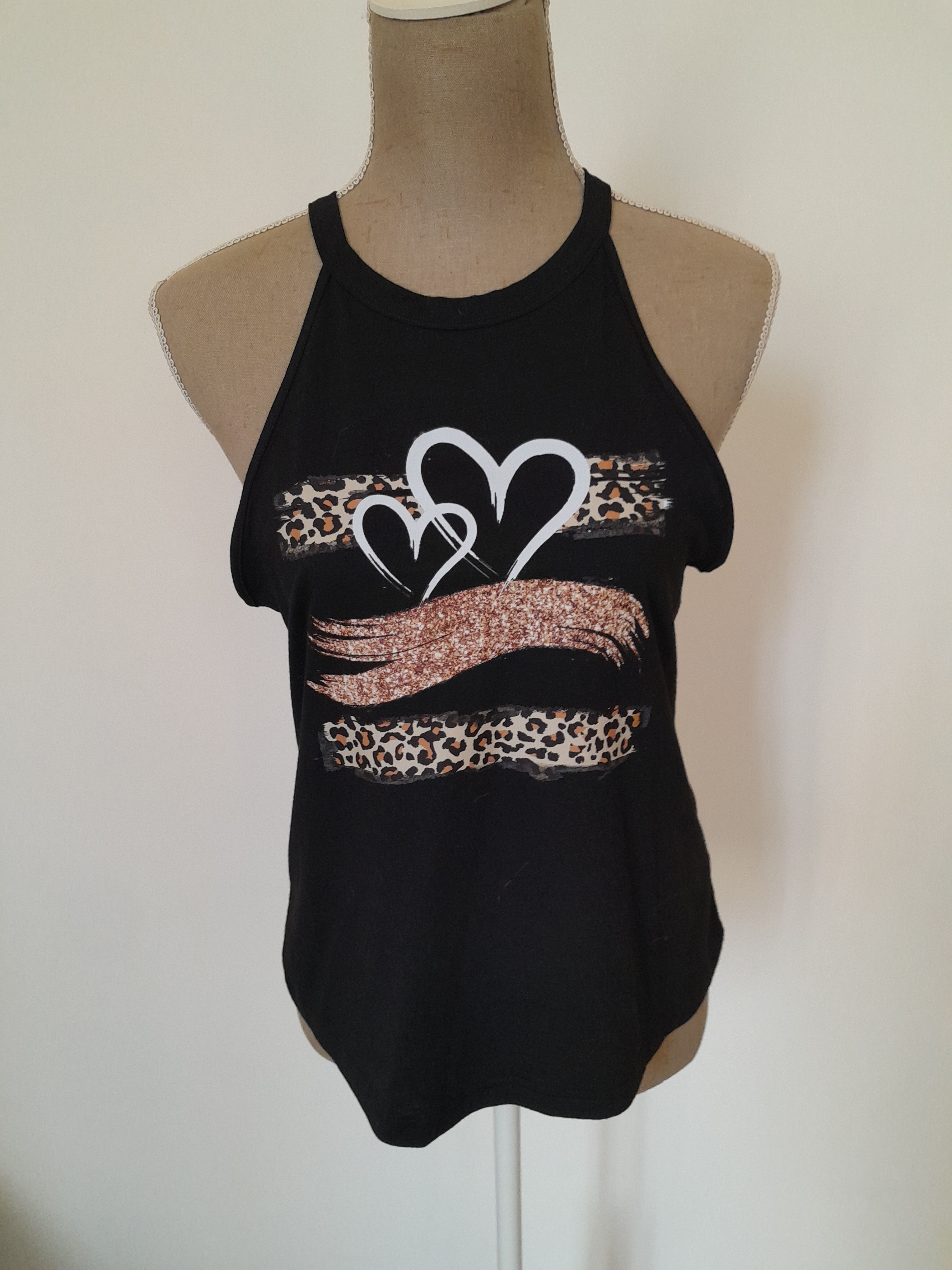 Un haut noir avec des coeurs et un motif léopard, top bustier, sur un mannequin.