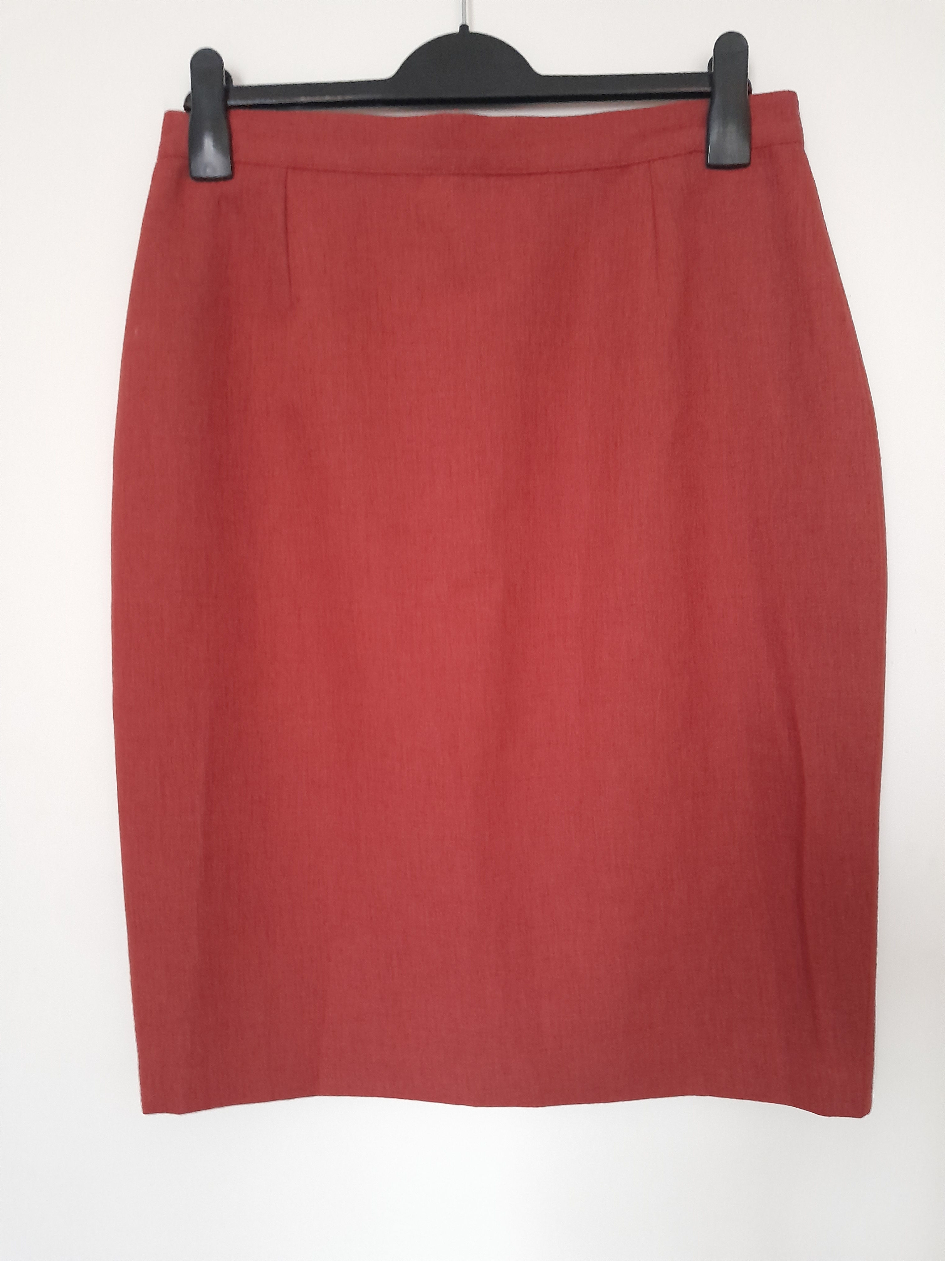 Jupe rouge en parfait état se trouve sur un cintre, seconde main.