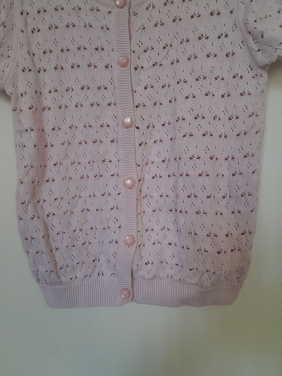 Miniature : Cardigan rose clair à boutons. Détails du textile, seconde main. 