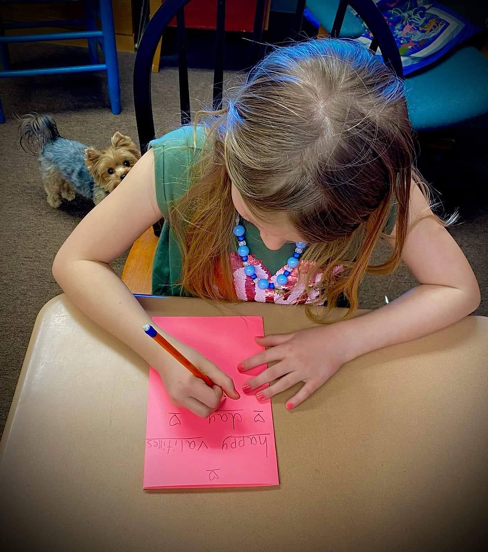 A girl makes a valentines card.