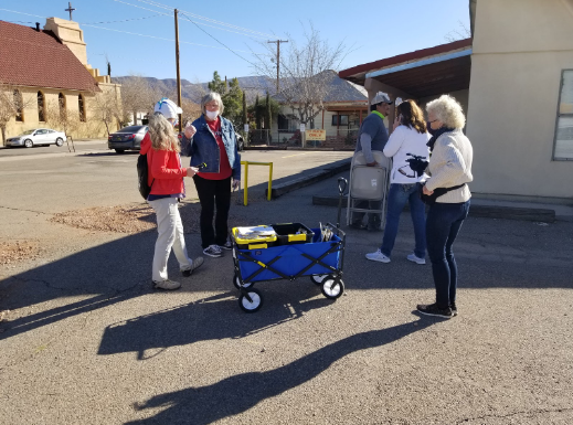 Stack Up volunteers talk with community members. All are wearing masks and talking from an appropriate social distancing spacing.