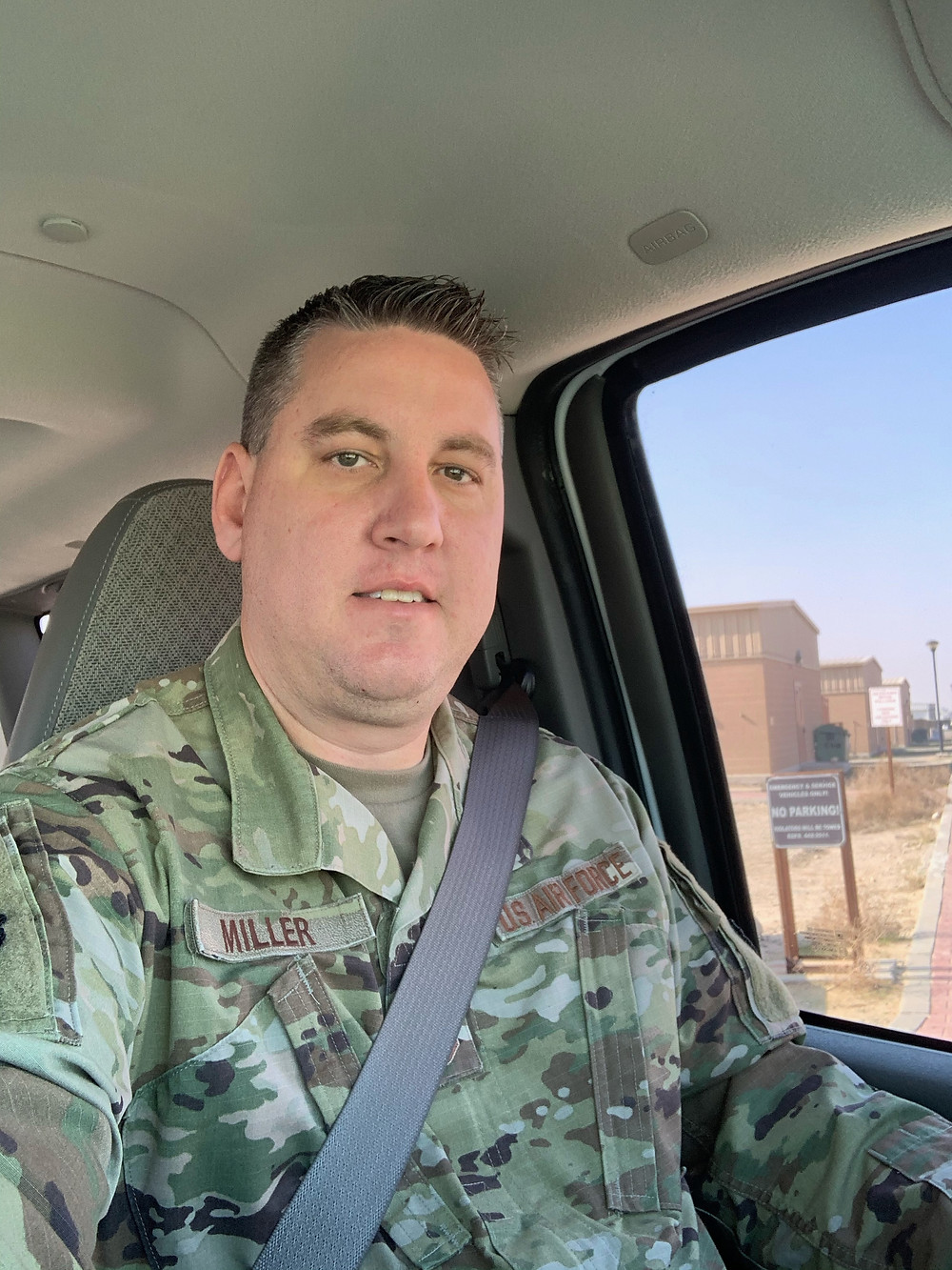 SSgt Derek Miller takes a selfie from his car. He is in Army uniform.