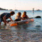 Deux personnes dans un kayak transparent sur l'eau, au coucher du soleil, sur la plage de Cavalière au Lavandou