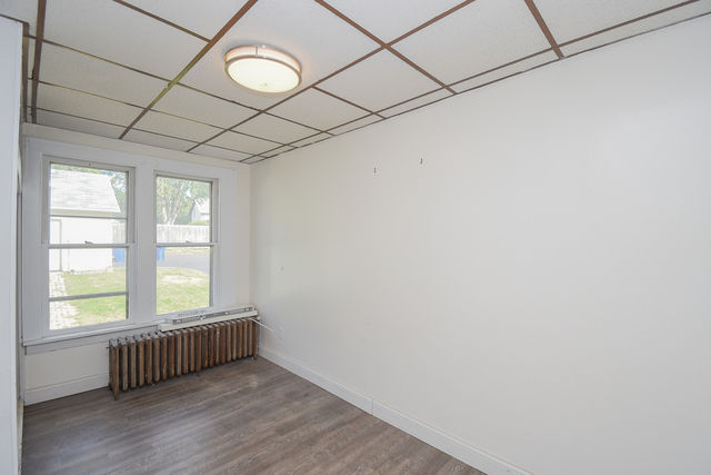 Small room with two windows and radiator, ideal for office or guest room
