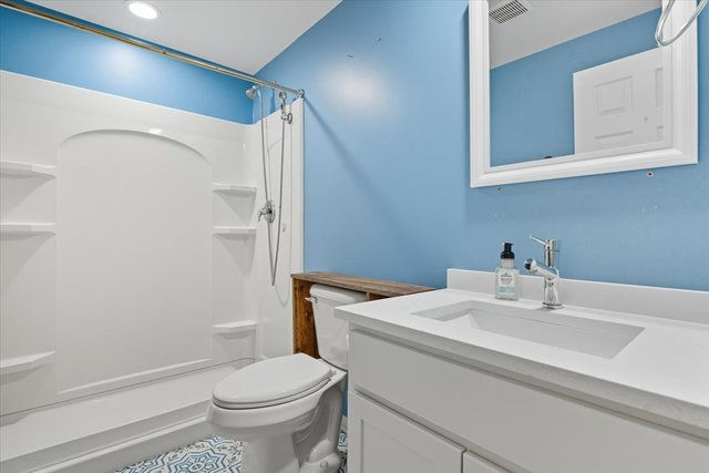 Guest bathroom with step-in shower and bright blue accent wall
