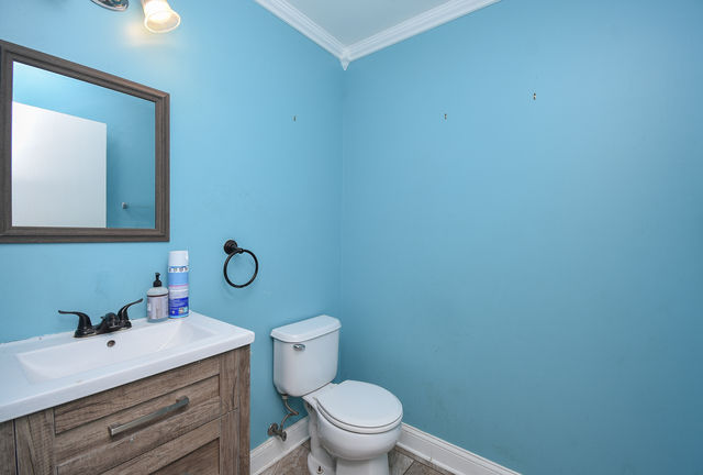 Half bathroom with blue walls and single vanity.
