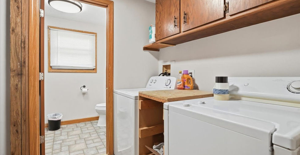 Laundry area with washer, dryer, built-in storage, and access to a nearby bathroom