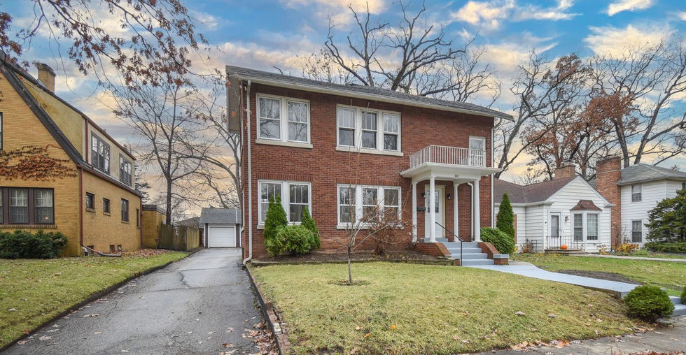 Front exterior view of a brick two-story home at 306 Oak Crest St, Waukegan, IL with a long driveway and neat lawn