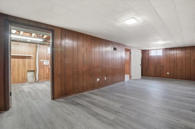 Large finished basement space with paneled walls, updated flooring, and flexible use.