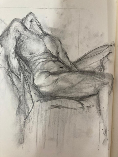 Boceto a carboncillo de una figura humana reclinada.