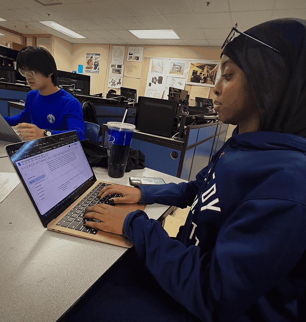 Aishah (operations member) working on her laptop in the CAD room