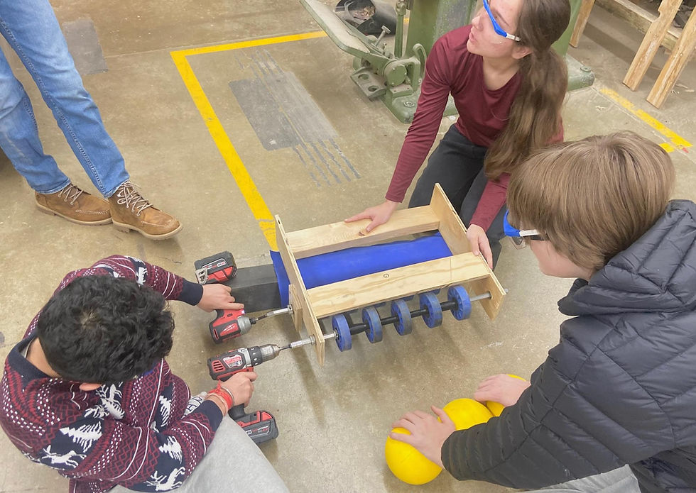 Build members testing the intake subsystem of the robot with the fuel balls.