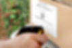 A Cipherlab RS35 scanning a 1d barcode on a food traceability bin label on a box of new clamshells with Traceback labels affixed to the bottom of the pack