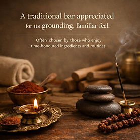 This image showcases a tranquil, grounding scene with traditional elements, including a burning candle, stone stack, incense, spices, and decorative elements. The composition evokes a sense of peace and relaxation, with the top of the image including text that reads, "A traditional bar appreciated for its grounding, familiar feel."