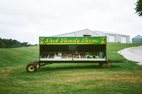 A farm stand set against the backdrop of a farm.