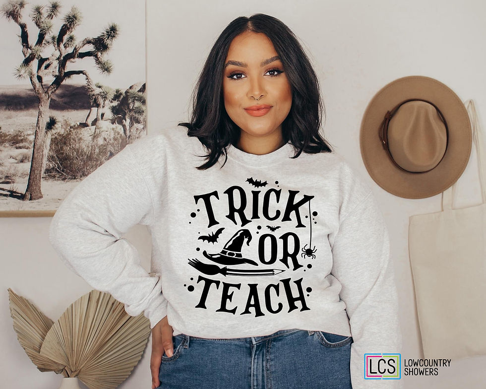 Woman wearing a white shirt featuring the phrase "Trick or Teach" with a ghost, pumpkin, books, and Halloween-themed design.