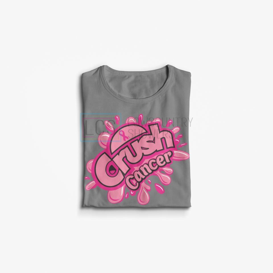 Folded gray Crush Cancer Shirt with bold pink and black lettering and pink splash graphics on a white background.