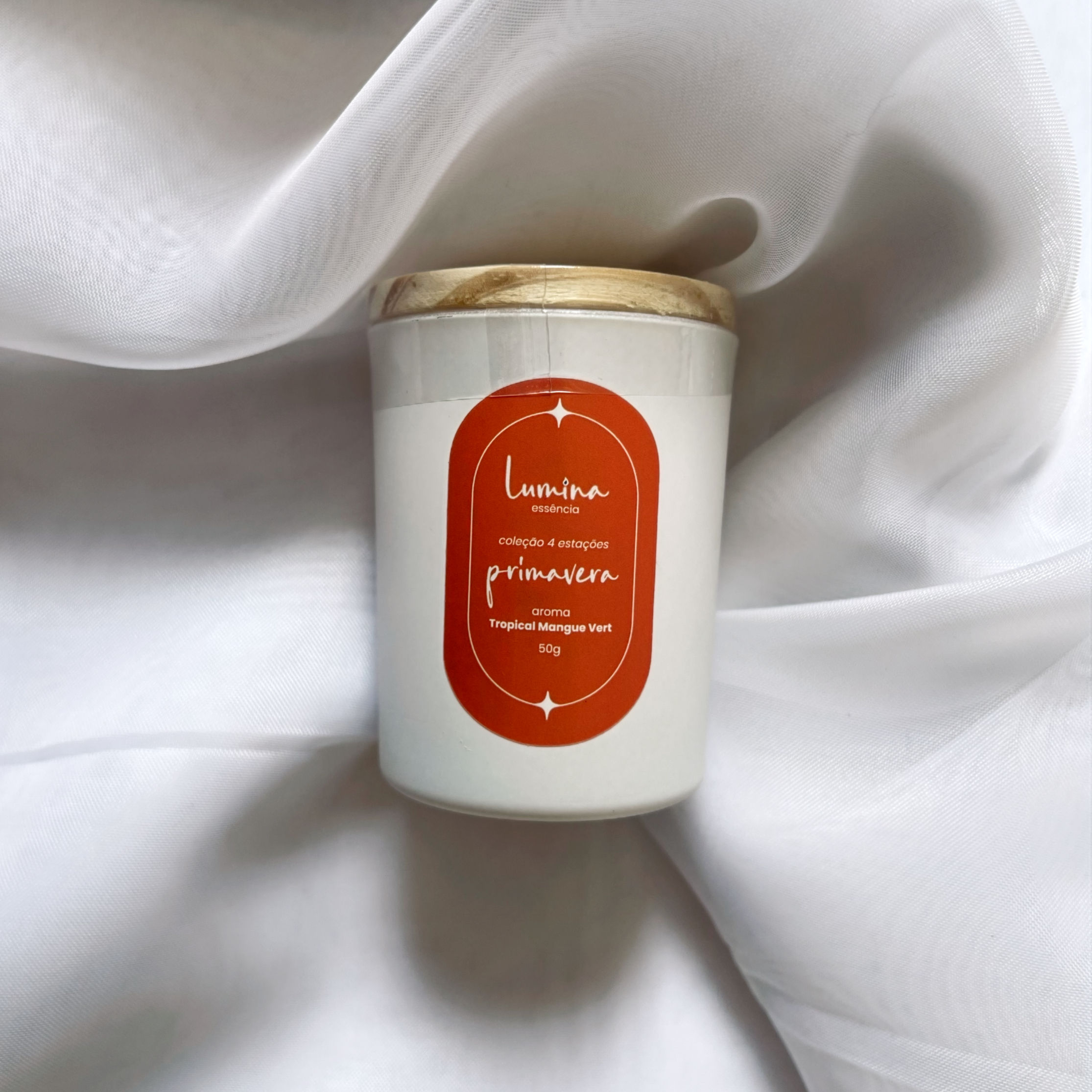 vela primavera, pote branco com rótulo laranja com escritos em branco