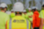 back view of students in bright vest and white helmets (safety gear), highlighting Fox Valley Technical College vest.