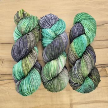 Three skeins of machine washable merino wool in green, brown and grey.