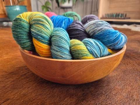 Selection of 8 Ply / DK Weight Yarns in a wooden bowl.