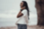 women standing on a beach smiling