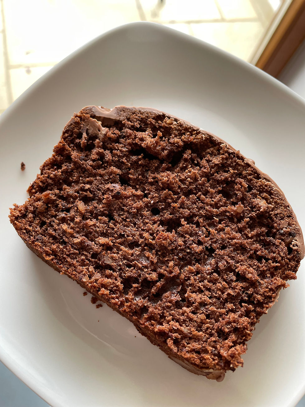 Ein Stück saftiger Schokokuchen auf einem weißen Teller