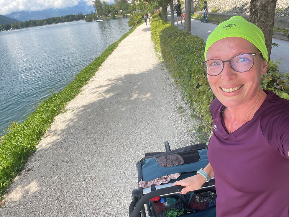 Junge Frau läuft mit Jogger und Kind am See