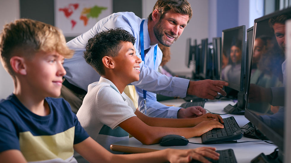 Teacher guiding students on computers in a classroom