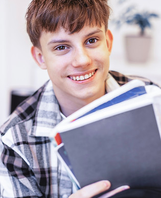 Smiling young man holding books