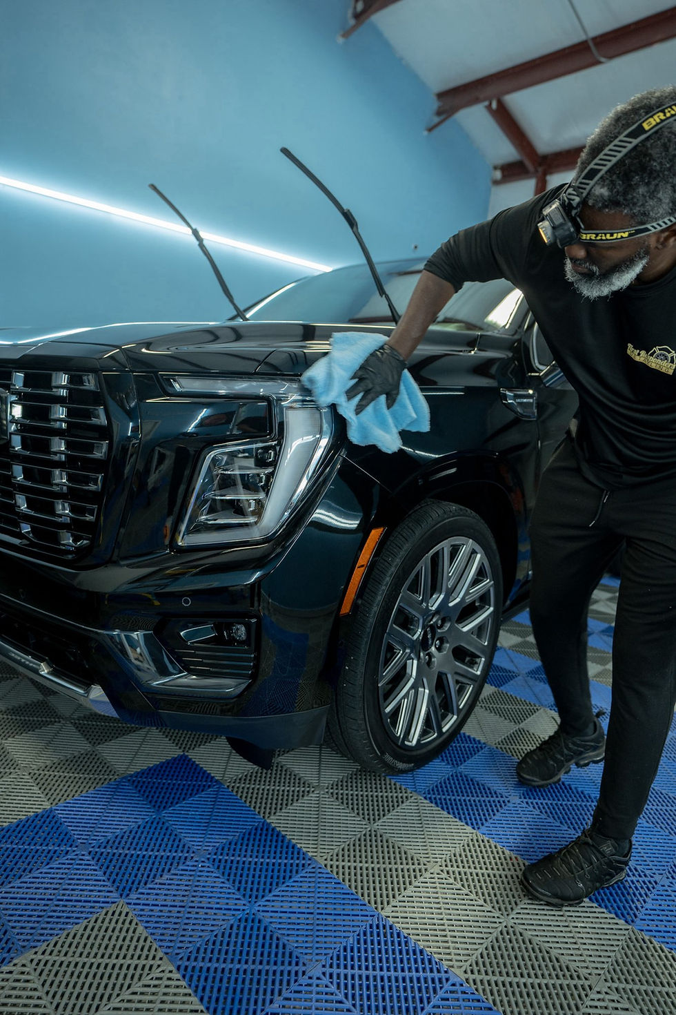 Eye-level view of a professional technician applying ceramic coating to a car door