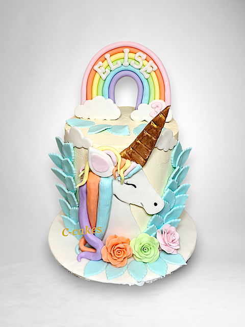 Magische unicorn taart met regenboog, pastelbloemen en speelse details – perfect voor kinderverjaardagen of themafeesten. Handgemaakt door C-Cakes.