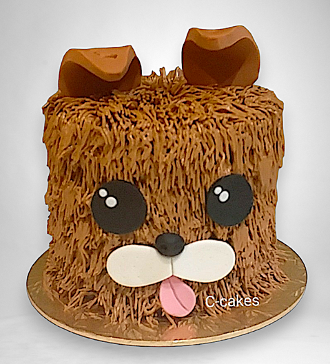 schattige kindertaart in de vorm van een fluffy bruine hond met tong uit de mond, speels design