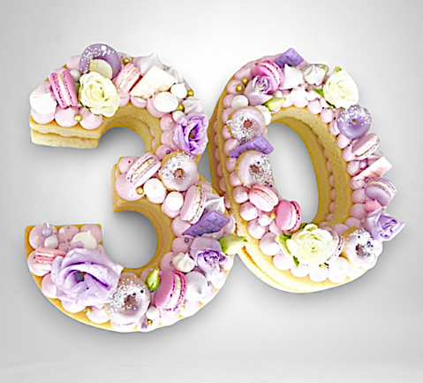 biscuitcijfers gevuld met crème, versierd met meringue, macarons en bloemen – number cake "30" filled with cream and topped with floral and pastel decorations