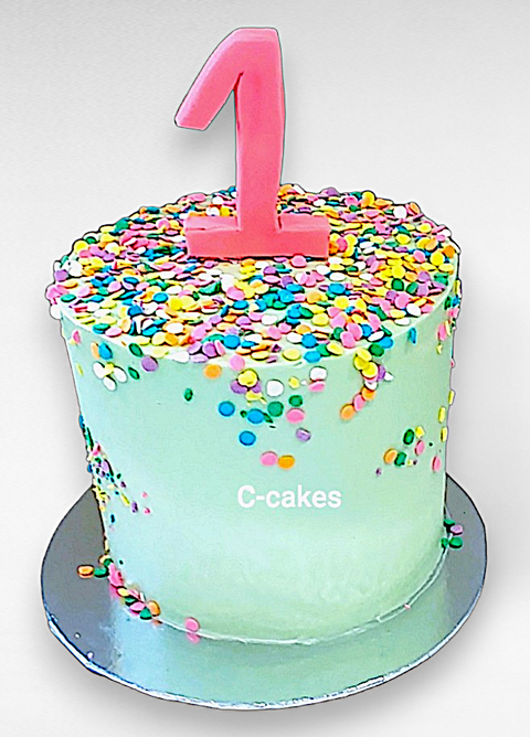 mintgroene verjaardagstaart met gekleurde sprinkles en fondant cijfer 1 – mint green birthday cake with colorful sprinkles and pink fondant number 1