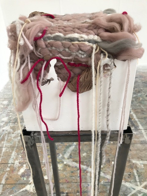 White box on plinth with textiles