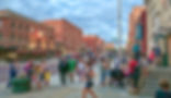 Haymarket District: Crowd of people walking and enjoying the vibrant atmosphere in the historic Haymarket District of Lincoln, Nebraska, with brick buildings and various shops and restaurants.