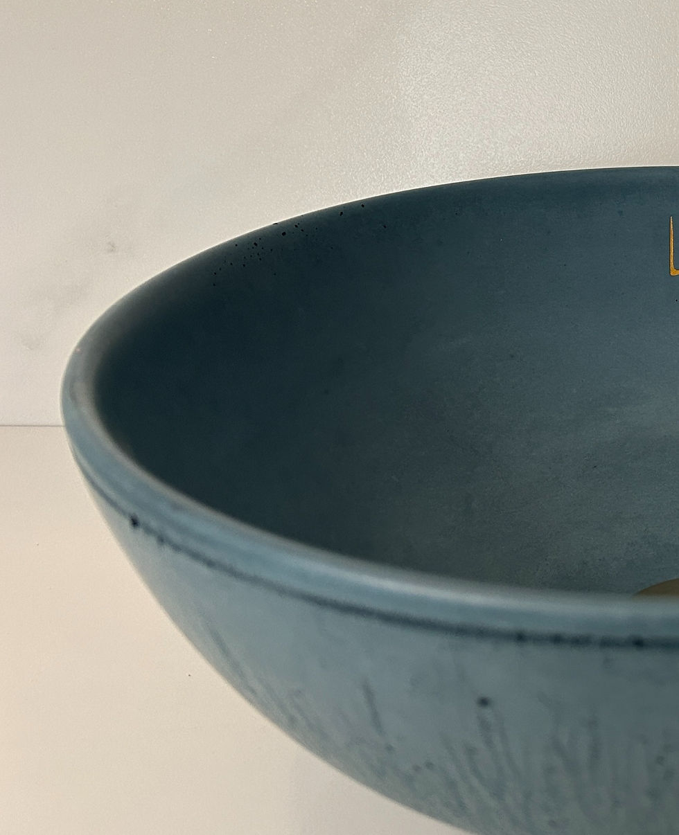 Miniature : Betonowa umywalka w kolorze jasno szarym. Tło drewniane, mała umywalka ovalna.