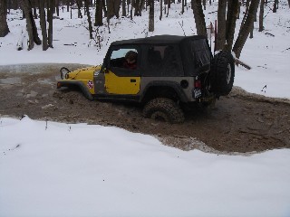 Yellow Jeep stuck in snowy mud