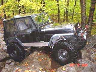Black Jeep Wrangler off-roading on rocks
