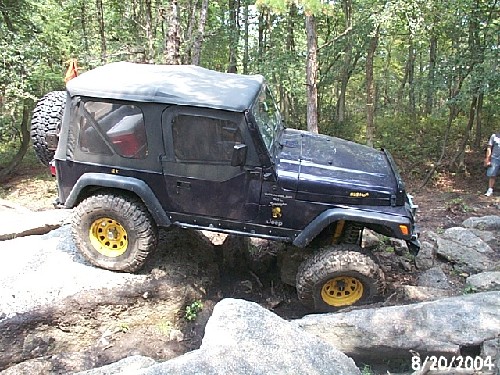 Dark-blue Jeep Wrangler navigating rocks; Long Island Off Road