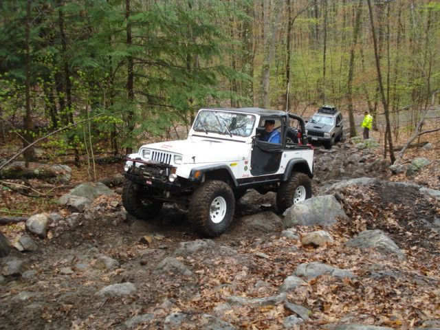 White Jeep navigating rocky terrain