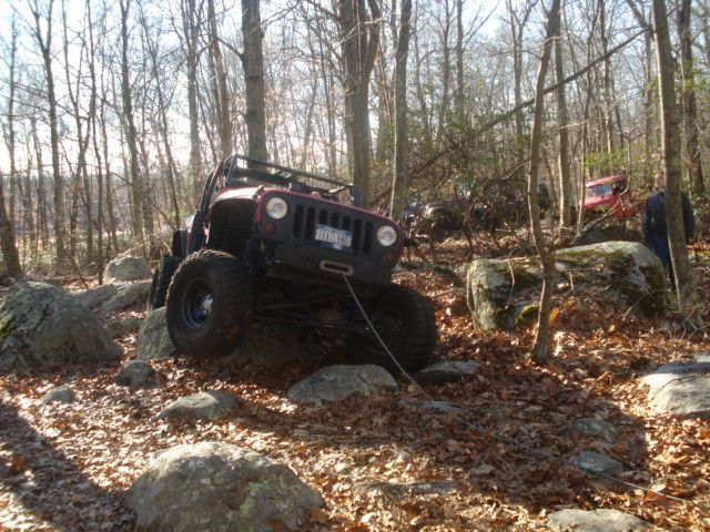 Red Jeep navigating rocky terrain