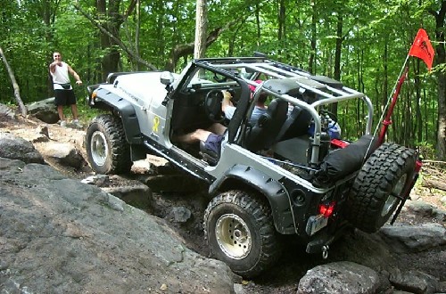 Silver Jeep traversing rocky terrain