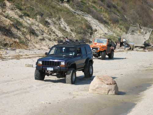 Jeeps driving on sandy beach